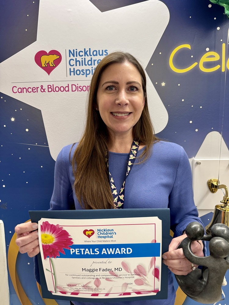 awardee wearing a headband of daisies, daisy award statue, and certificate.