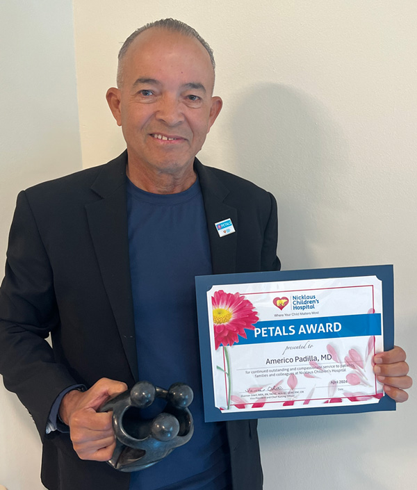 awardee wearing a headband of daisies, daisy award statue, and certificate.