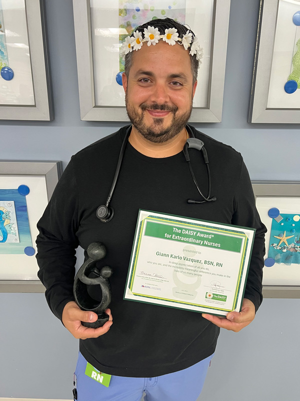 awardee wearing a headband of daisies, daisy award statue, and certificate.