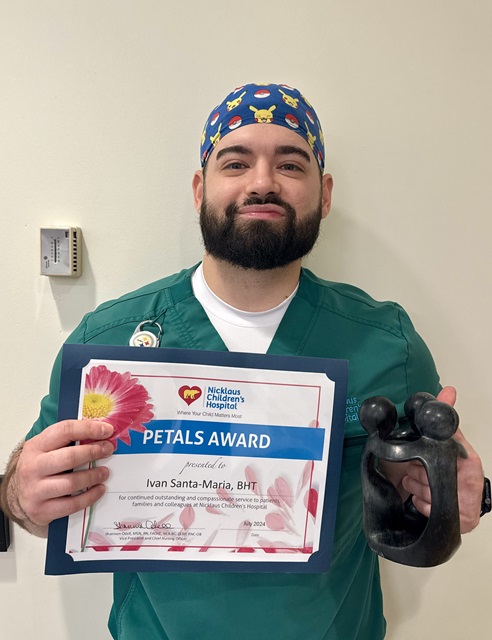 awardee wearing a headband of daisies, daisy award statue, and certificate.